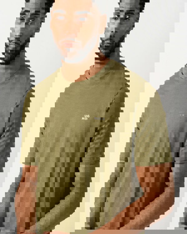 detail shot of a model wearing a HUGO Dero222 Mens Cotton-Jersey T-Shirt with Logo Print in Open Green