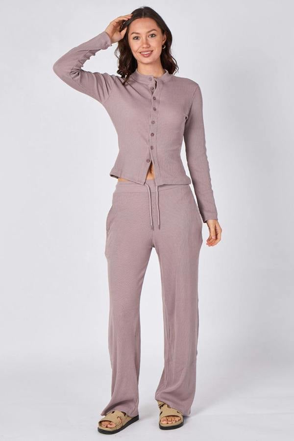 Woman wearing a matching cardigan and pants set on a white background