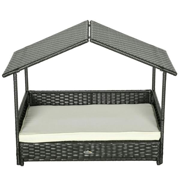 Dark rattan-style dog house bed with open front and cream cushion