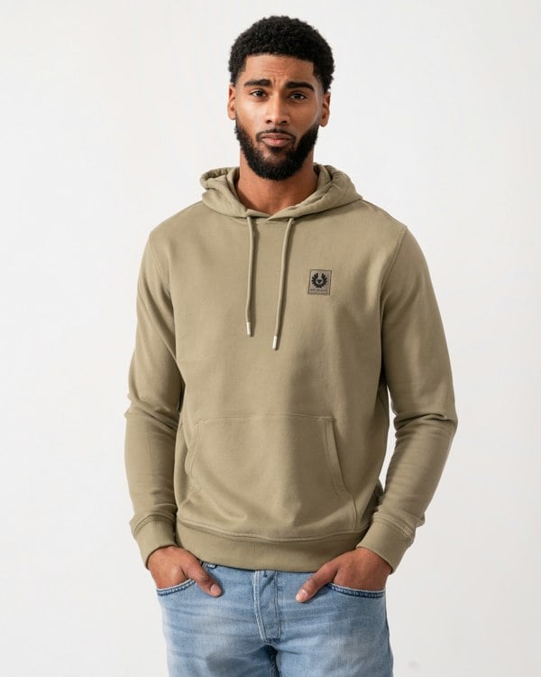 Model wearing a Belstaff Mens Pullover Logo Patch Hoodie in Fatigue Green