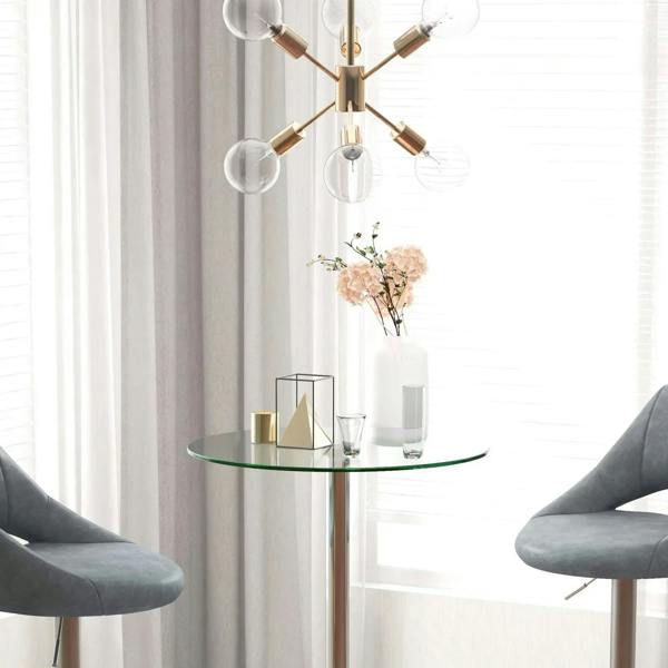 Round high bar table with clear glass top and polished metal pedestal frame