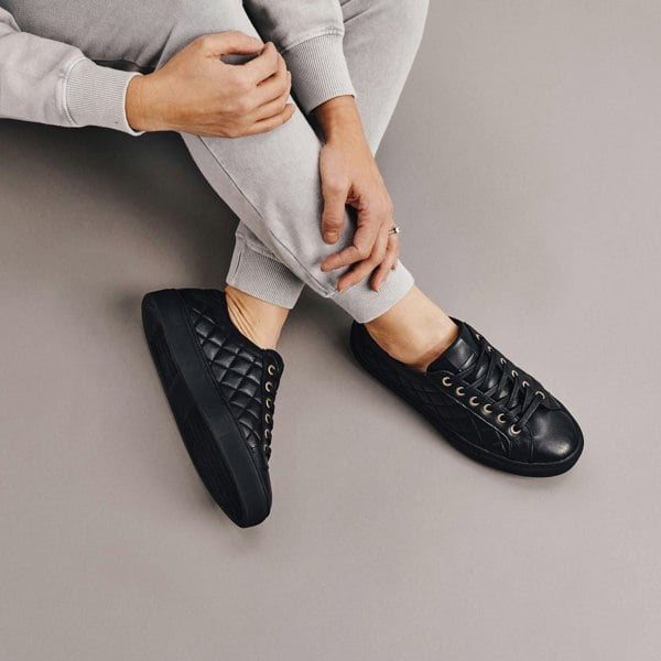 black quilted leather trainers on legs