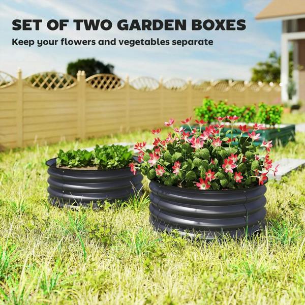Set of two dark grey metal garden boxes with green plants and pink flowers on grass