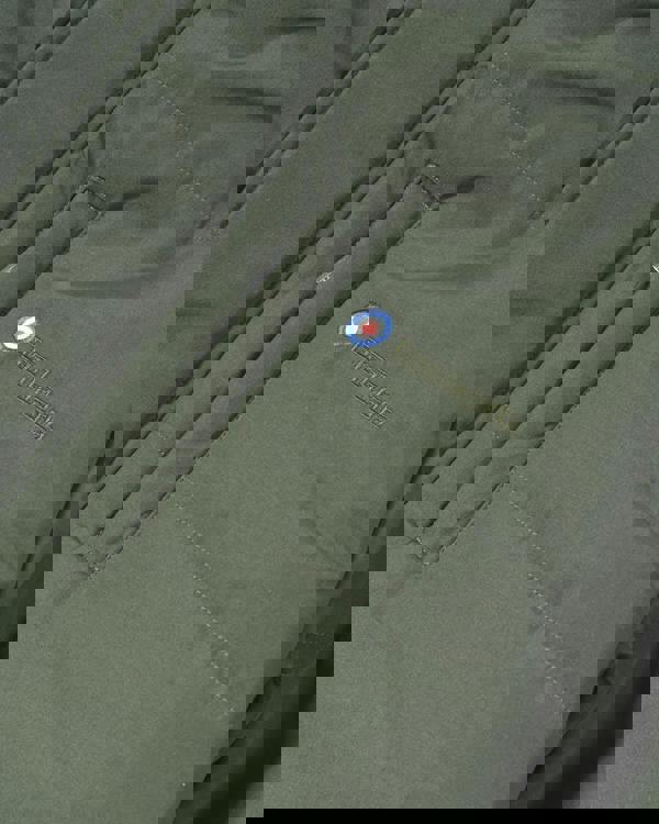 Lambretta Mens Padded Hooded Classic Badge Parka, close-up of the olive green jacket showing the embroidered Lambretta logo, badge, and waterproof zipper.