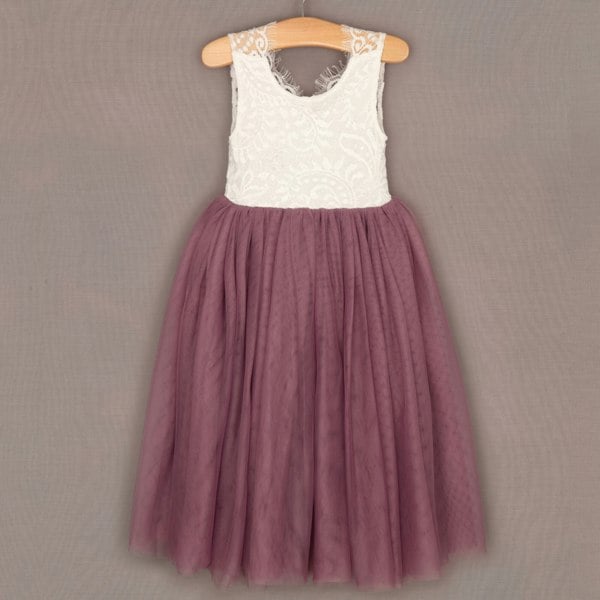 White lace top and purple tulle skirt dress on a hanger against a gray background