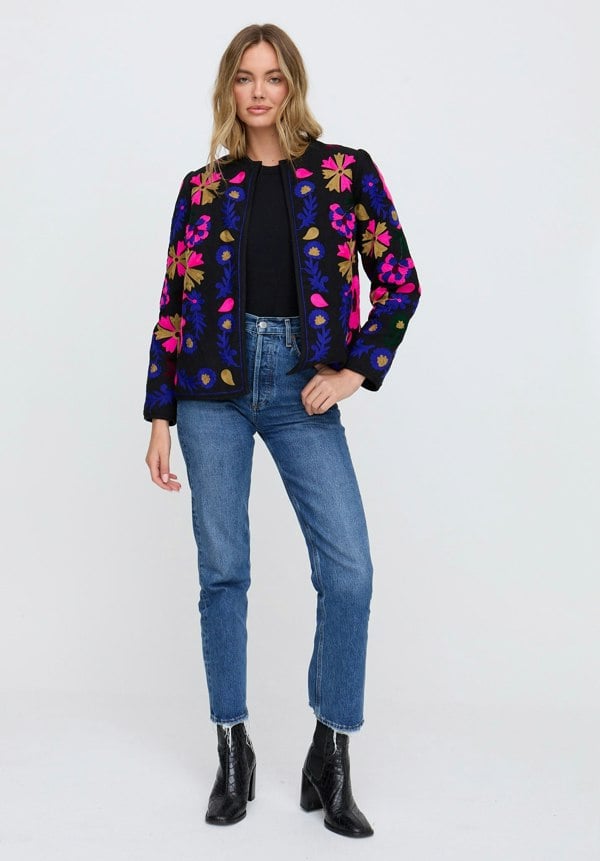 Woman wearing a colorful jacket with floral patterns on a white background