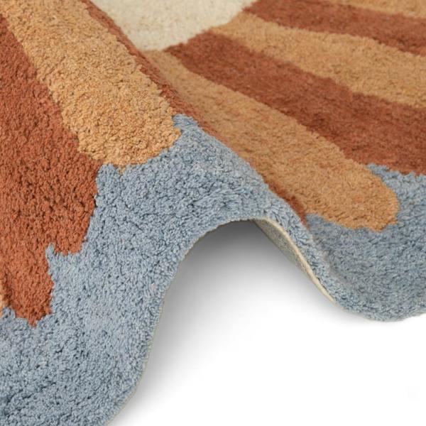 Close-up of a multicolored rug with brown, beige, and blue stripes on a white background.
