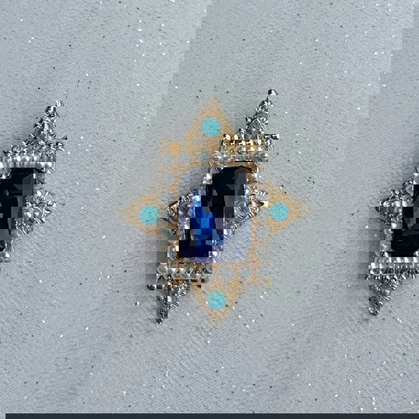 Blue vintage brooch, gold tone star shaped setting, large faceted sapphire blue gemstone centre, surrounded by white faux pearls and turquoise bead accents, ornate statement jewellery, antique inspired accessory, elegant gift for her
