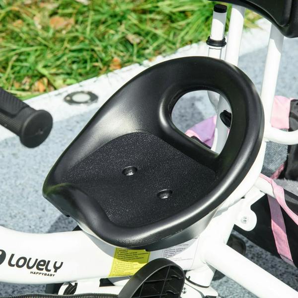 Black footrest and front wheel area of pink kids trike