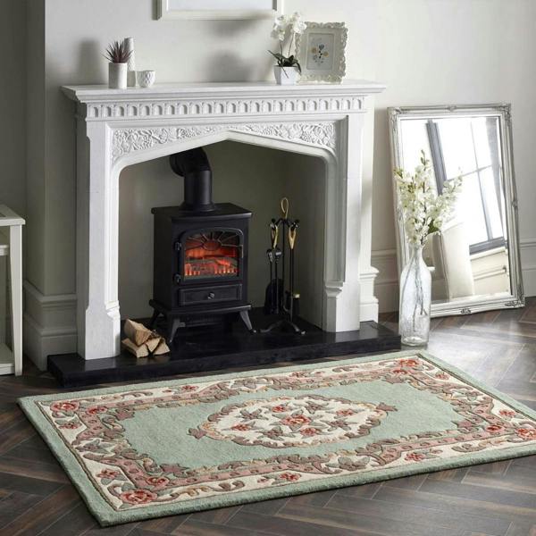 Decorative rug in front of a white fireplace with a black stove.
