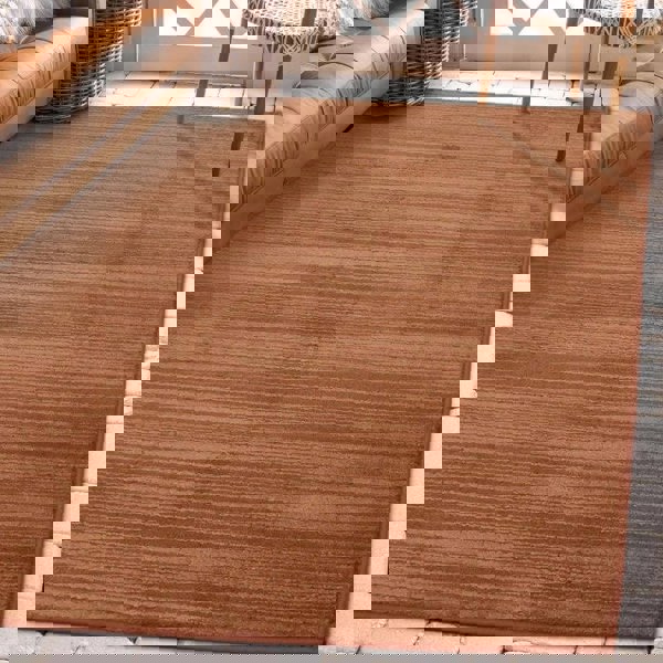 Arlo Textured Rug in warm brown tone with soft stripes, enhancing a cozy living room space.