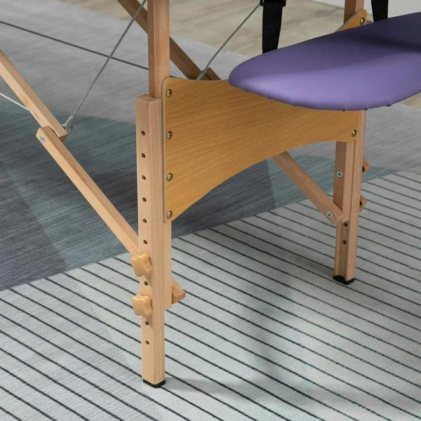 Wooden support frame corner of a purple folding massage bed with padded surface