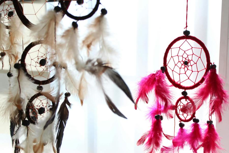 Hanging dreamcatchers with round webs and feather fringe in white and pink