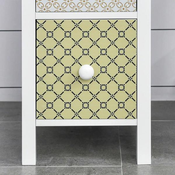 Patterned drawer front with green geometric design and white round knob on white cabinet.