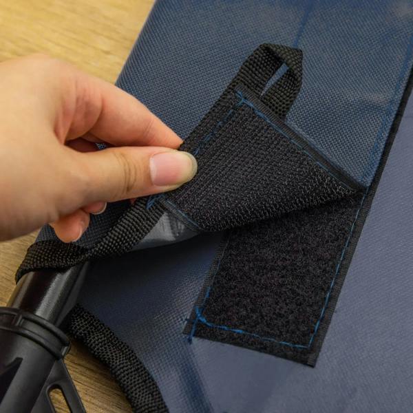 Blue elevated pet bed corner with black straps and hand fastening detail