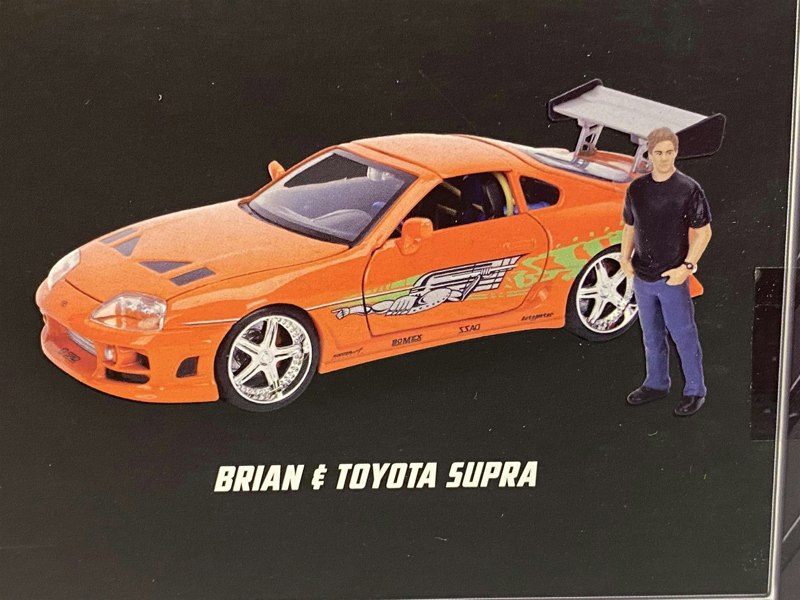 a man standing next to a toy car