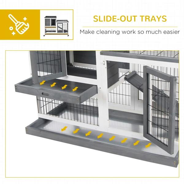 Grey wooden rabbit hutch with slide-out trays and wire doors, on caster wheels