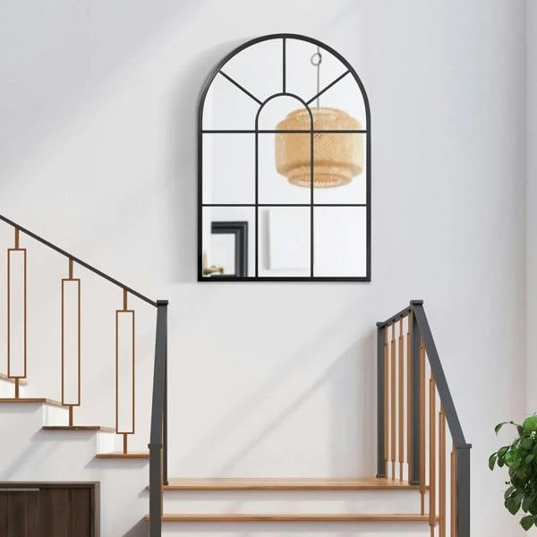 Arched grid mirror with black frame mounted on wall, window-style grid sections.