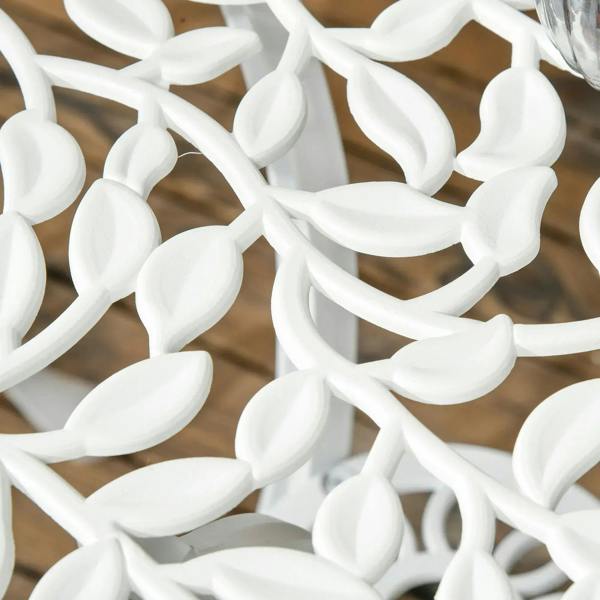 Close-up of white ornate chair lattice cutouts with leaf-shaped scrollwork