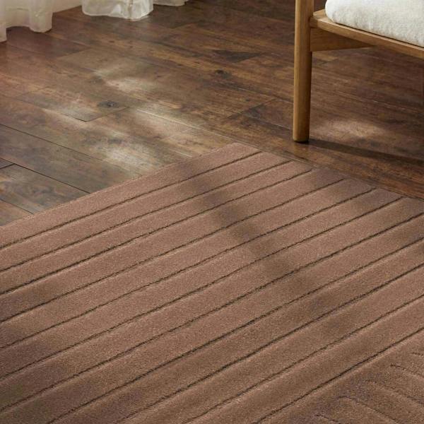 Wooden flooring with a bed in the background