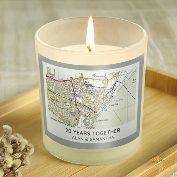 A lit scented candle in a frosted glass jar featuring a custom Ordnance Survey map label centred on Shoeburyness, personalised with "20 YEARS TOGETHER" and "ALAN & SAMANTHA" on a wooden tray.