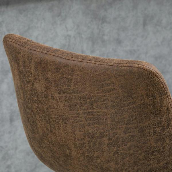 Brown upholstered bar stool seat corner with piping and stitched edge, close-up.