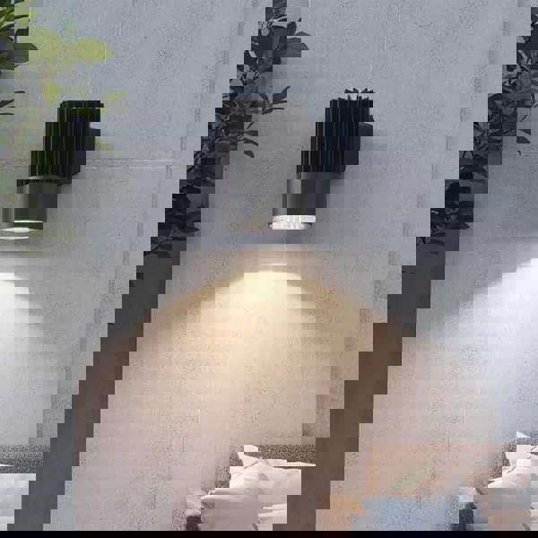 black large outdoor wall downlight mounted on a concrete outside wall 