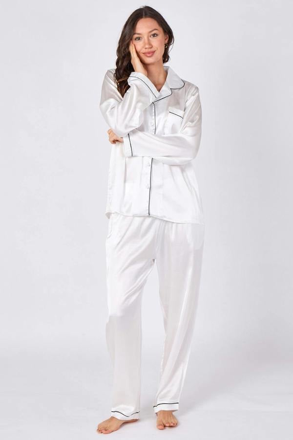 Woman wearing a white satin pajama set on a white background