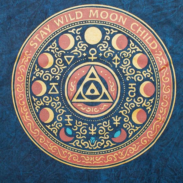 Close-up of circular Stay Wild Moon Child graphic print on blue t-shirt