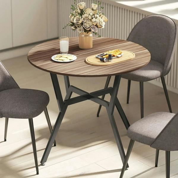 Round brown dining table with black metal legs and smooth wood tabletop
