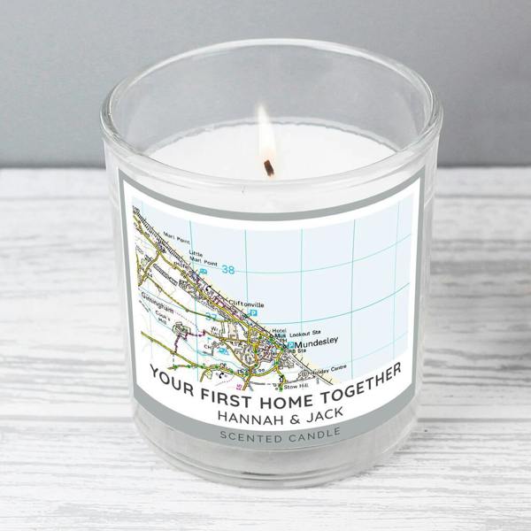A lit personalised new home map candle in a clear glass jar featuring a vanilla-scented white wax and a custom map label centred on Mundesley.