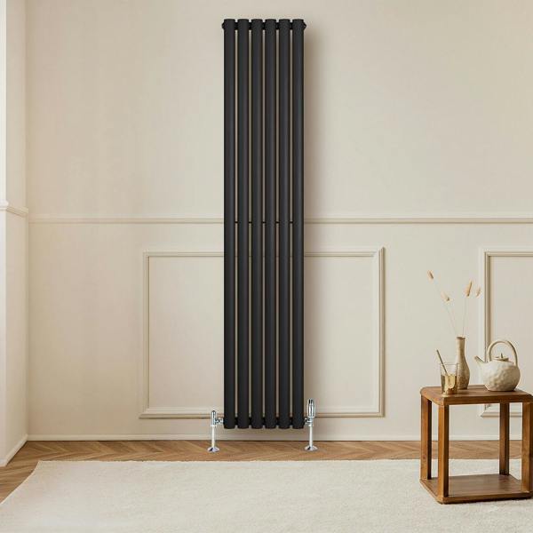 Sleek black oval single column radiator with polished valves, mounted on a light wall, enhancing modern interior decor