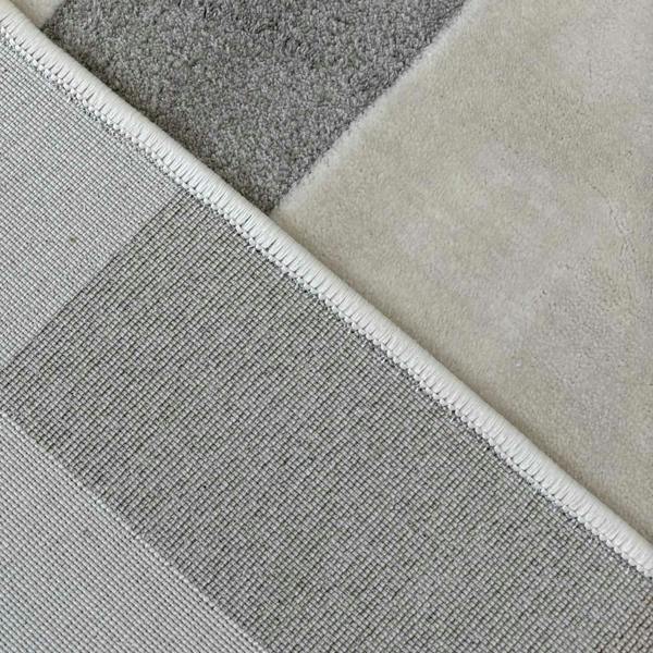 Close-up of various gray and beige rug samples.