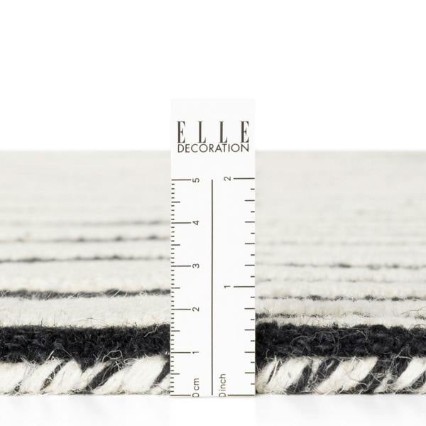 Textured black and white fabric swatch with a ruler for scale, branded 'ELLE Decoration'.