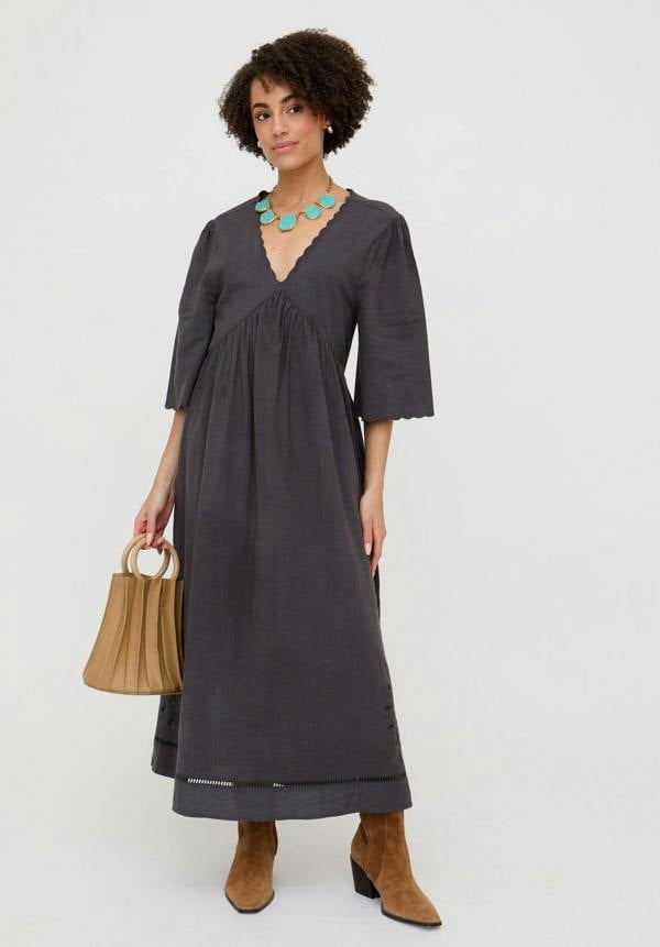 Woman wearing a gray dress with a plain background