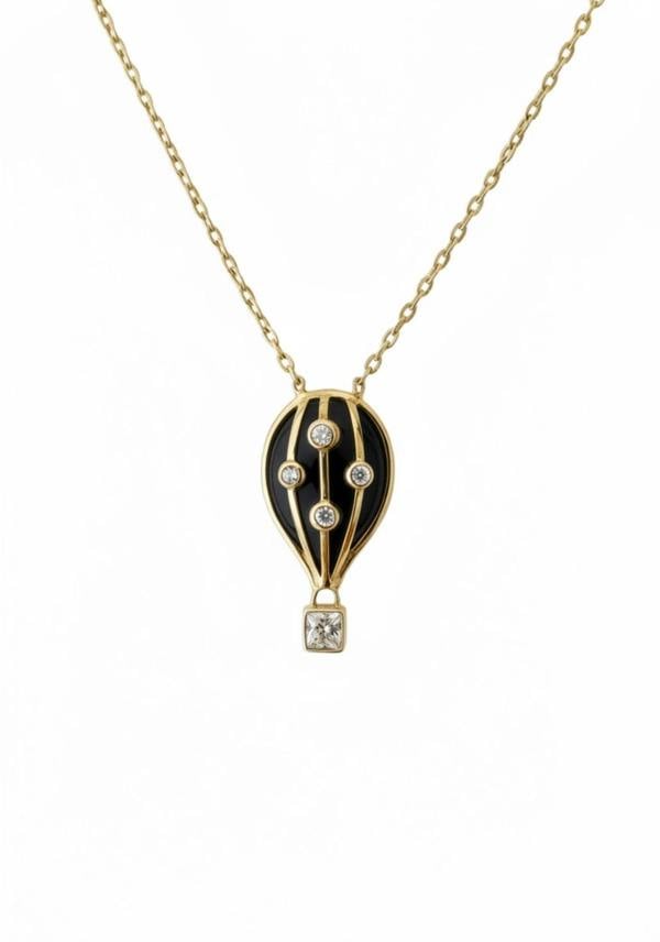 Gold necklace with a black hot air balloon pendant on a white background
