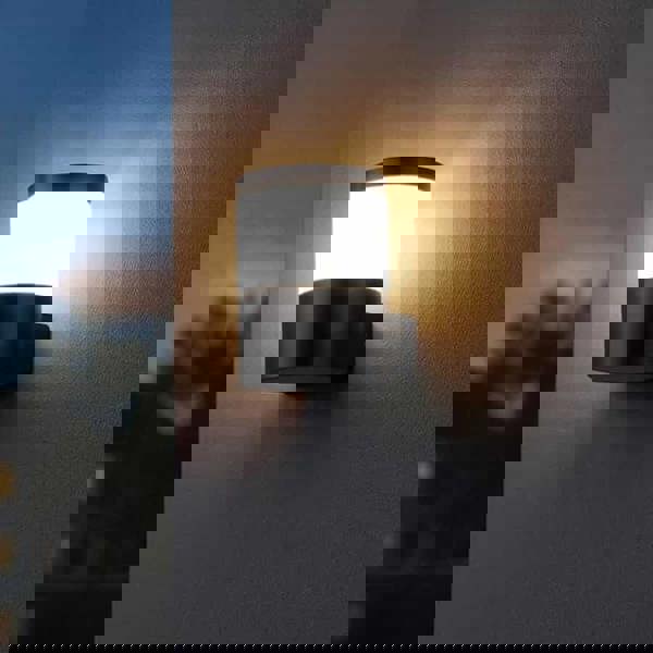 black outside wall lantern mounted on a white textured wall outside of a house