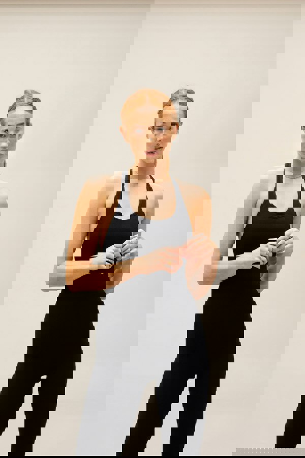 Black seamless sculpting shaping one piece bodysuit with built in shelf bra and removable pads for yoga, pilates, gym and exercise.