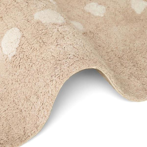 Close-up of a beige bath mat with white circular patterns on a white background