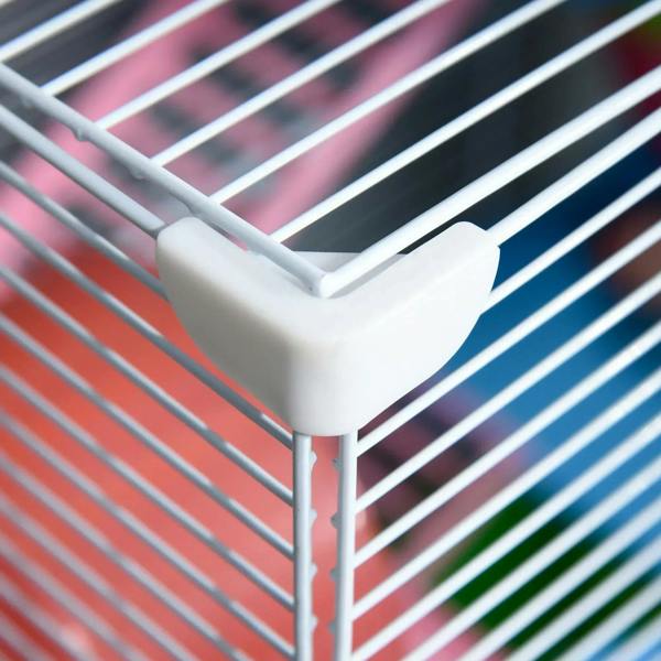 White plastic corner bracket connecting wire bars on a hamster cage