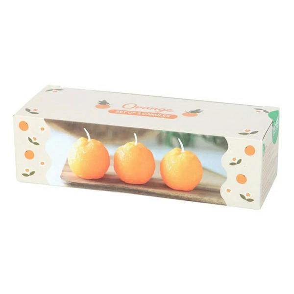 Orange shaped candle set box showing three candles with white wicks.