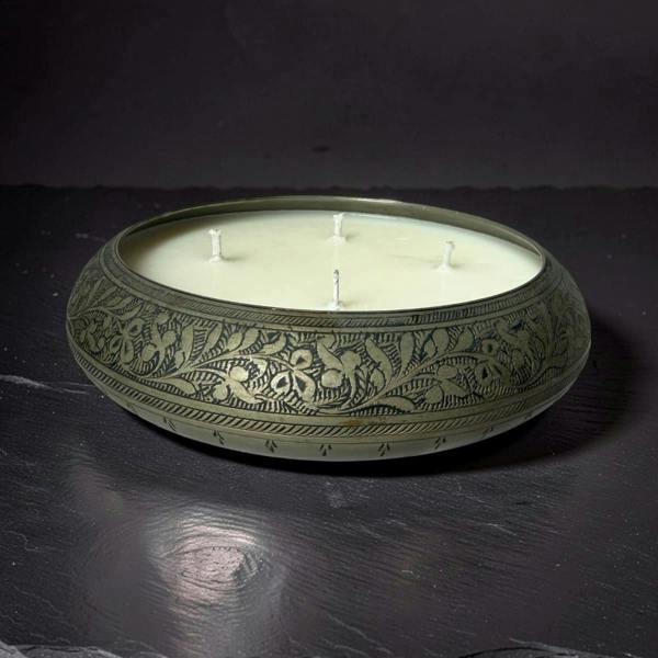 Decorative candle in an ornate holder on a dark surface