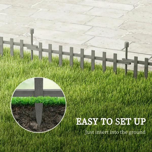 Grey wooden landscape edging fence with vertical pickets bordering a lawn