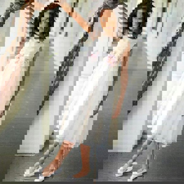 Girl leaning on a tree in a ivory flower girl dress