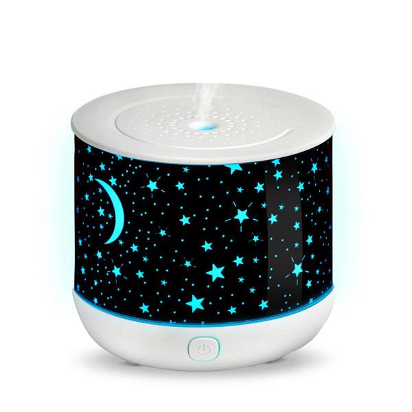 The Rio Dream Time Aroma Diffuser acts as a humidifier and night light, with glowing blue stars and a crescent moon on white, releasing visible mist from the top for a calming, night sky-inspired ambiance.