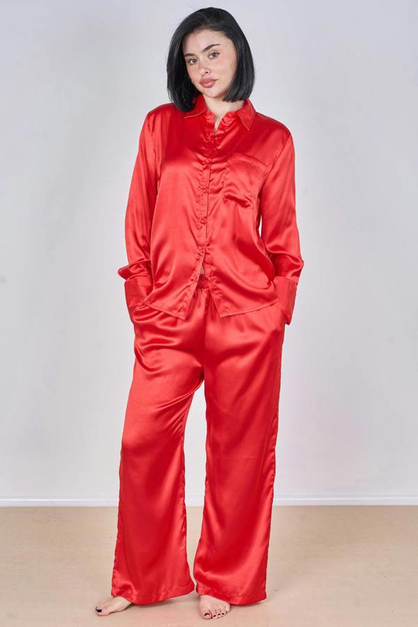 Person wearing a red satin pajama set against a plain background