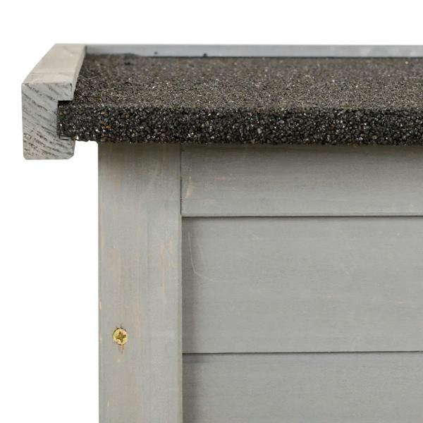 Grey wooden shed corner with roof overhang and shingle edge detail