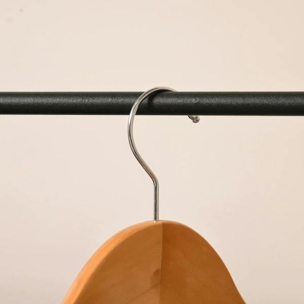 Black metal hanging rail with attached orange wooden clothes hanger