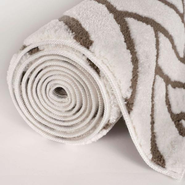 Rolled-up rug with beige and brown pattern on a light gray background