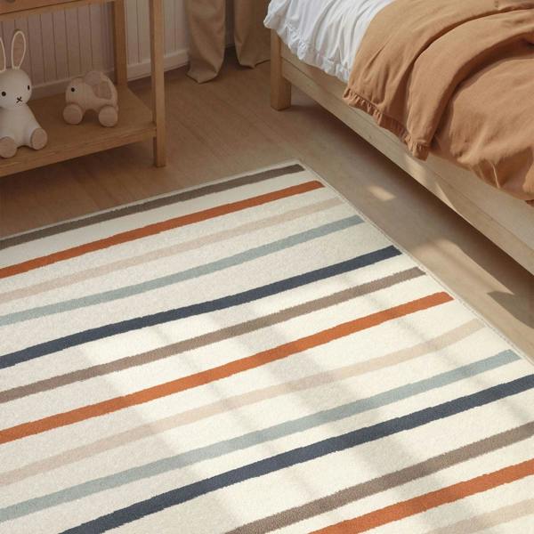 Striped rug on a wooden floor with a bed and shelf in the background